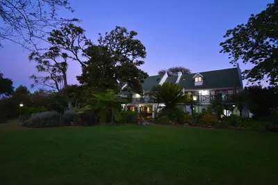 a house with a green roof at night at Cuckoos Nest Guest House in Louis Trichardt