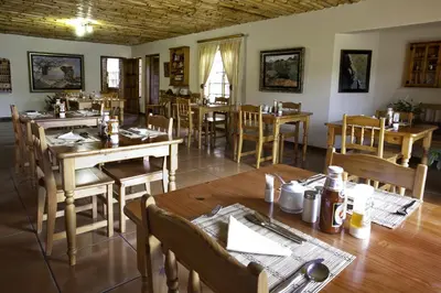 a dining room with wooden tables and chairs at Peter's Guesthouse in Pretoria