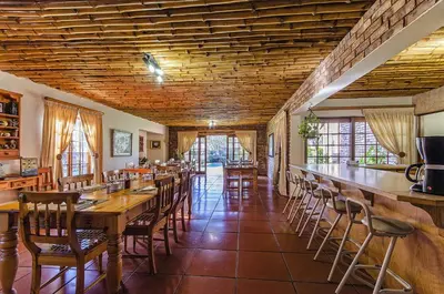 a dining room with wooden tables and chairs at Peter's Guesthouse in Pretoria
