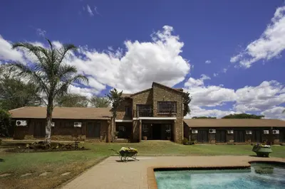 a large brick house with a pool in front of it at Peter's Guesthouse in Pretoria
