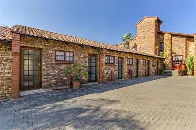 a brick building with windows on a brick street at Peter's Guesthouse in Pretoria