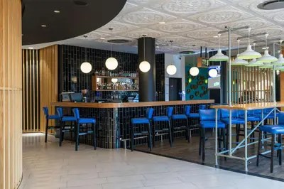 a bar in a restaurant with blue bar stools at Park Inn by Radisson Polokwane in Polokwane