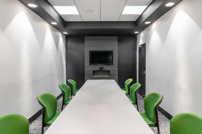 a conference room with a long table and green chairs at Park Inn by Radisson Polokwane in Polokwane