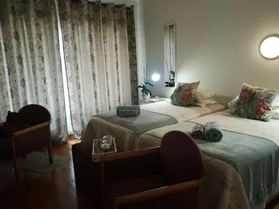 a bedroom with two beds and a chair and a window at 800@Merton in Pretoria