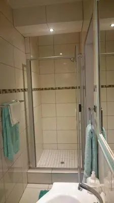 a bathroom with a shower and a white sink at 800@Merton in Pretoria