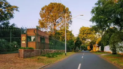 an empty street with a building and a fence at 800@Merton in Pretoria