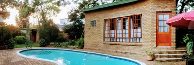 a house with a swimming pool next to a building at 800@Merton in Pretoria