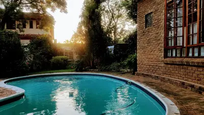a swimming pool in a yard next to a brick building at 800@Merton in Pretoria