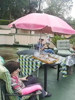 two people sitting at a table under a pink umbrella at 800@Merton in Pretoria