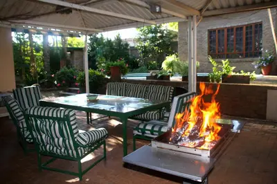 a patio with a table and chairs and a fire pit at 800@Merton in Pretoria
