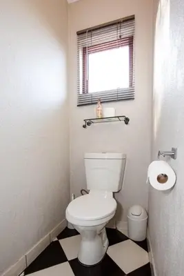 a bathroom with a white toilet and a window at Windmills Rest in Pretoria