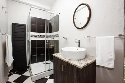 a bathroom with a sink and a shower at Windmills Rest in Pretoria