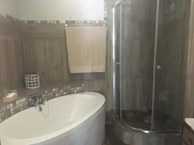 a bathroom with a bath tub and a shower at Windmills Rest in Pretoria