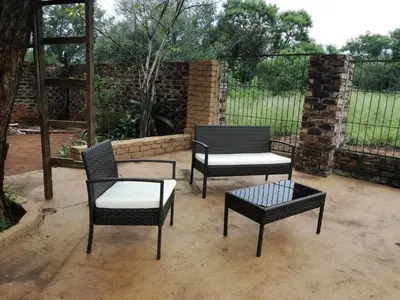 three chairs and a table on a patio at Roundhouse Marloth Park in Marloth Park