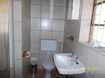 a small bathroom with a toilet and a sink at Roundhouse Marloth Park in Marloth Park