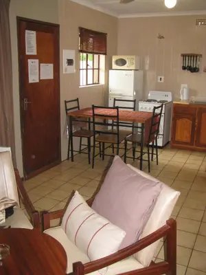 a living room with a table and chairs and a kitchen at Eagles Nest Chalets in Hazyview