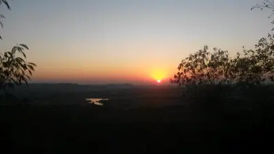a sunset with the sun setting in the distance at Eagles Nest Chalets in Hazyview