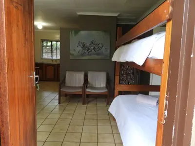 a bedroom with a bunk bed and a table and chairs at Eagles Nest Chalets in Hazyview