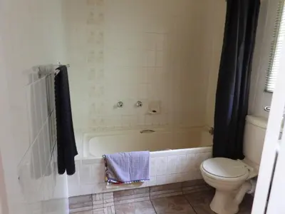 a bathroom with a white tub and a toilet at Eagles Nest Chalets in Hazyview