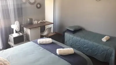 a hotel room with two beds and a desk at Lallapanzi Country Stay in Ermelo