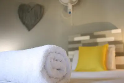 a towel on a bed with a heart on the wall at Lallapanzi Country Stay in Ermelo