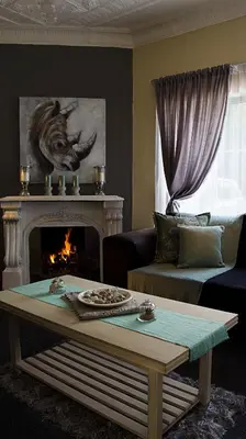 a living room with a fireplace and a table at Lallapanzi Country Stay in Ermelo