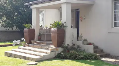 a house with potted plants on the front porch at Lallapanzi Country Stay in Ermelo