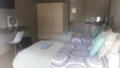 a bedroom with a large bed with blue pillows at Lallapanzi Country Stay in Ermelo