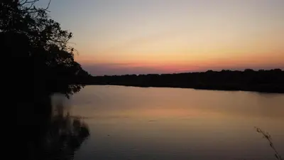 a view of a lake at sunset at River Hill Lodge in Komatipoort