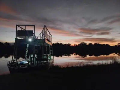 a boat sitting on the water at sunset at River Hill Lodge in Komatipoort