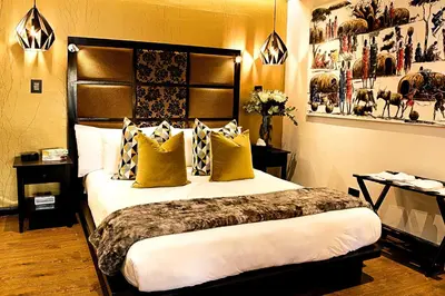 a hotel room with a large bed with yellow pillows at Kgarebana Boutique Guesthouse in Tweefontein