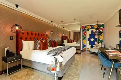 a hotel room with two beds and a desk at Kgarebana Boutique Guesthouse in Tweefontein