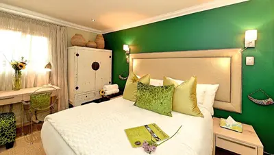 a green bedroom with a bed and a green wall at Kgarebana Boutique Guesthouse in Tweefontein