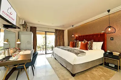 a hotel room with a bed and a desk and a desk at Kgarebana Boutique Guesthouse in Tweefontein