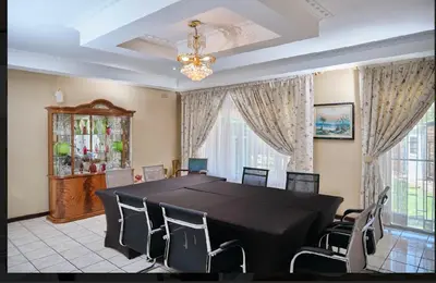 a dining room with a black table and chairs at Oleratong Guest House in Evander