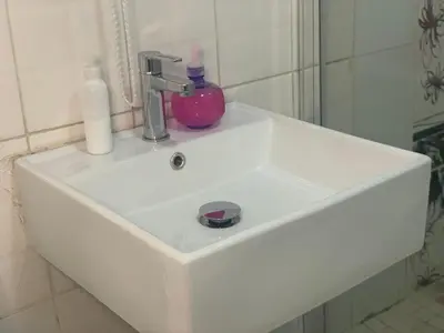 a white sink in a bathroom with a mirror at Oleratong Guest House in Evander