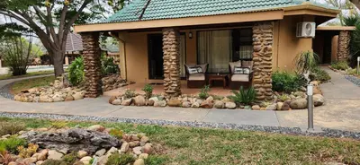 a house with a porch with a table and chairs at Motlala Game Lodge in Hoedspruit