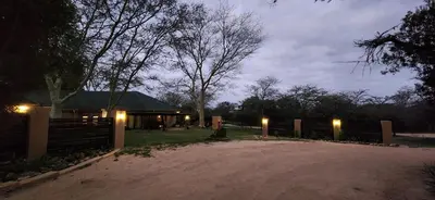 a house with a fence and lights in the yard at Motlala Game Lodge in Hoedspruit