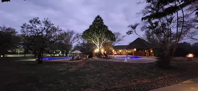 a house with a pavilion in a park at night at Motlala Game Lodge in Hoedspruit