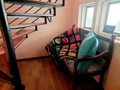 a chair with a pillow sitting next to a bunk bed at Adorable Designs in Pretoria