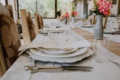 a table with plates and silverware on top of it at White Linen Guesthouse in Tierpoort