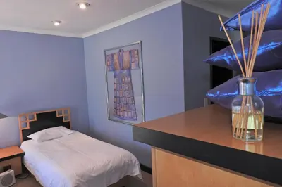 a bedroom with a bed and a vase on a counter at Willow Place Guest House in Midrand