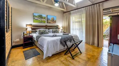 a bedroom with a large bed and a large window at Dreamfields Guesthouse in Hazyview