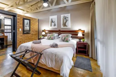 a bedroom with a large bed and a brick wall at Dreamfields Guesthouse in Hazyview