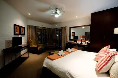 a bedroom with a large bed and a living room at Oxbow Country Estate in Erasmus
