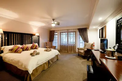 a bedroom with a large white bed and a desk at Oxbow Country Estate in Erasmus