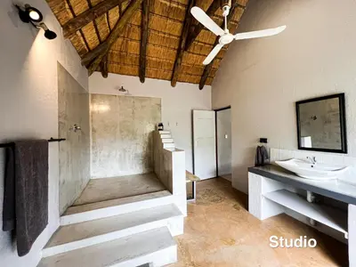 a bathroom with a shower and a sink at 24 Degrees South Country Estate in Hoedspruit