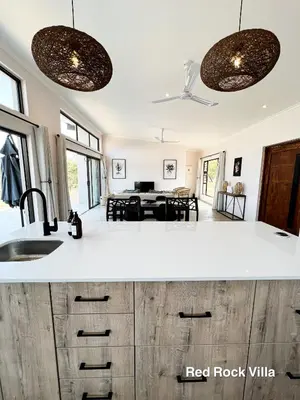 a kitchen with a sink and a living room at 24 Degrees South Country Estate in Hoedspruit