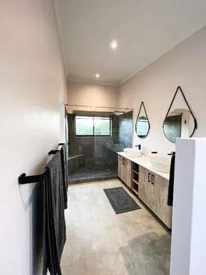 a bathroom with two sinks and a shower at 24 Degrees South Country Estate in Hoedspruit