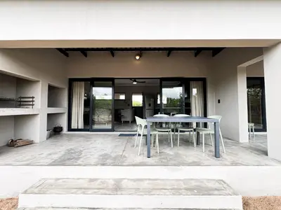 a patio with a table and chairs in a house at 24 Degrees South Country Estate in Hoedspruit